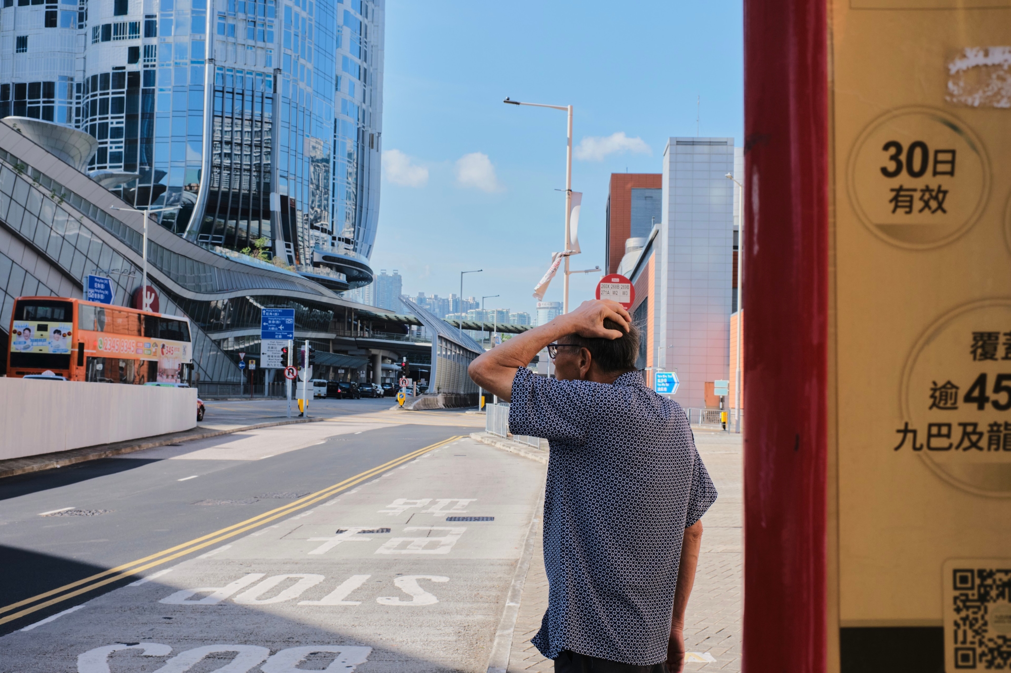 Man at bus stop, city skyline in background