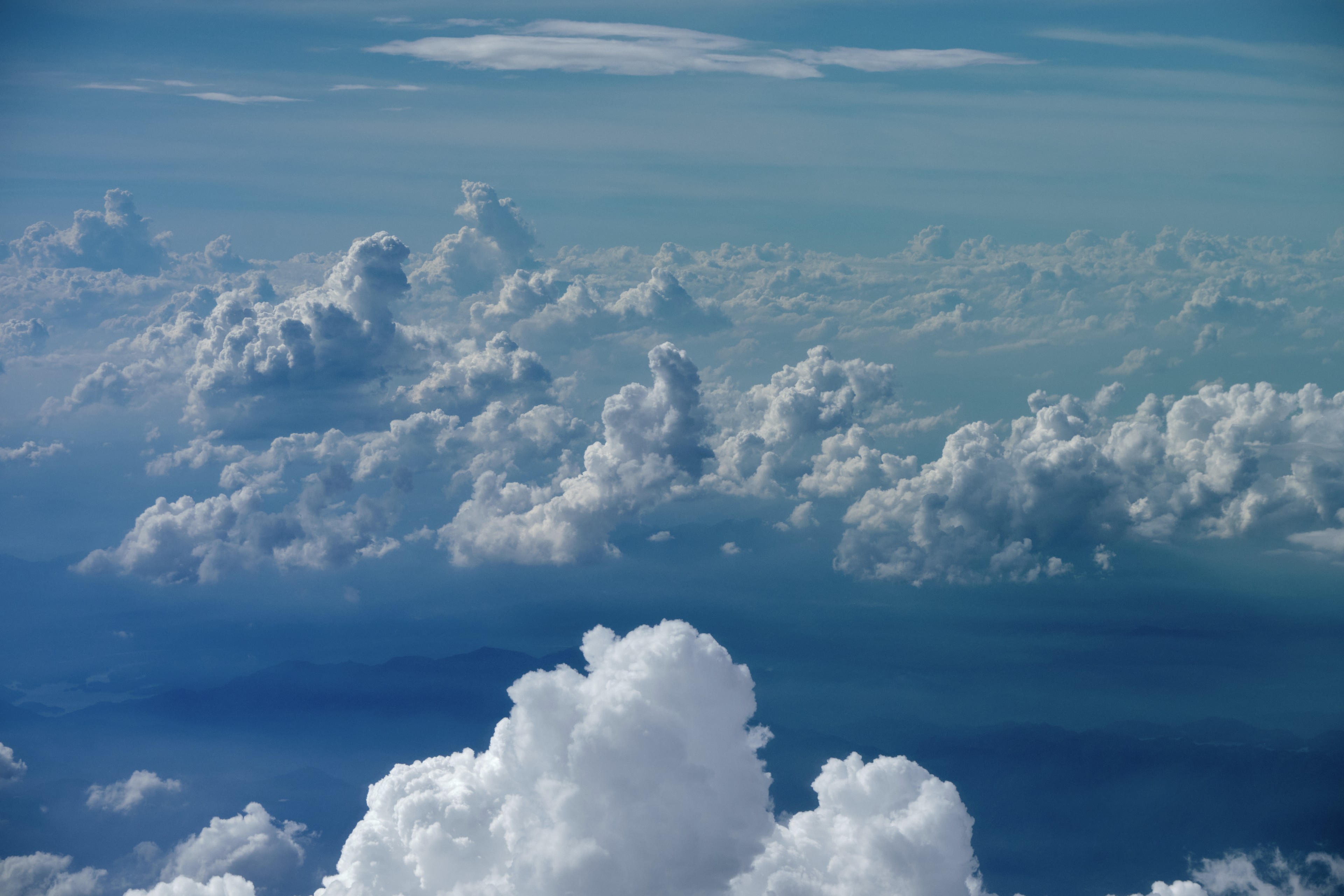 Aerial view of layered white cumulus clouds against a blue sky