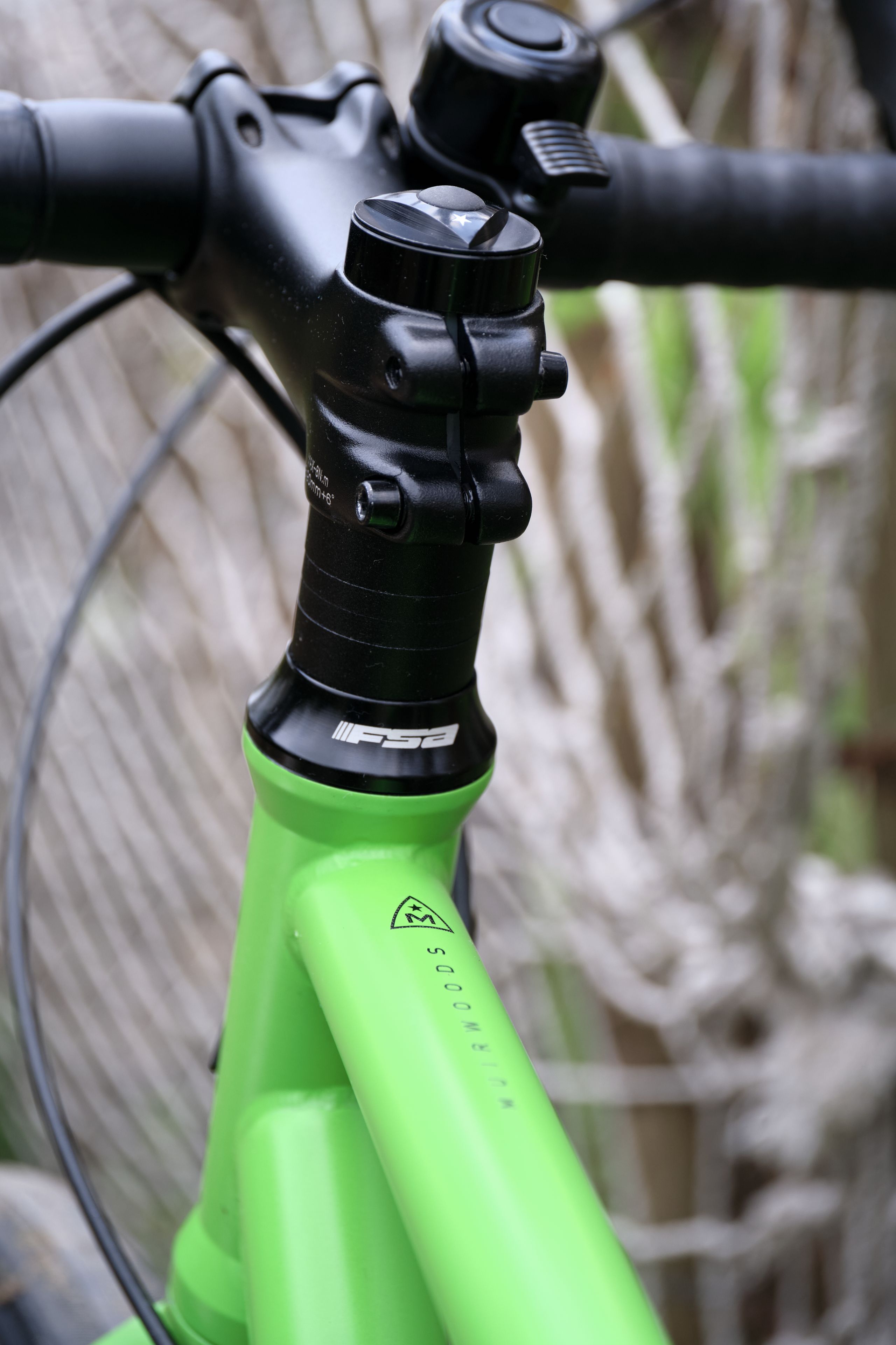 Close-up of a bright green bicycle frame with black handlebars and stem