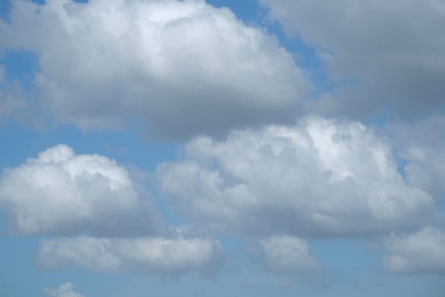 White cumulus clouds against a blue sky