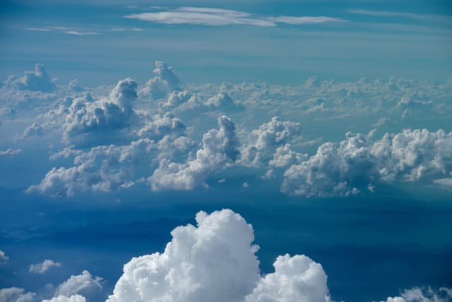 Aerial view of layered white cumulus clouds against a blue sky