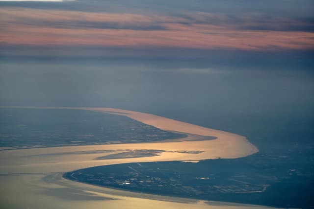 Aerial view of winding river reflecting twilight sky