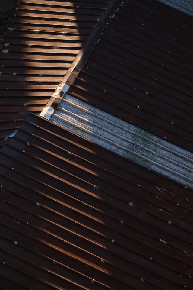 Corrugated metal roofs under diagonal sunlight and shadows